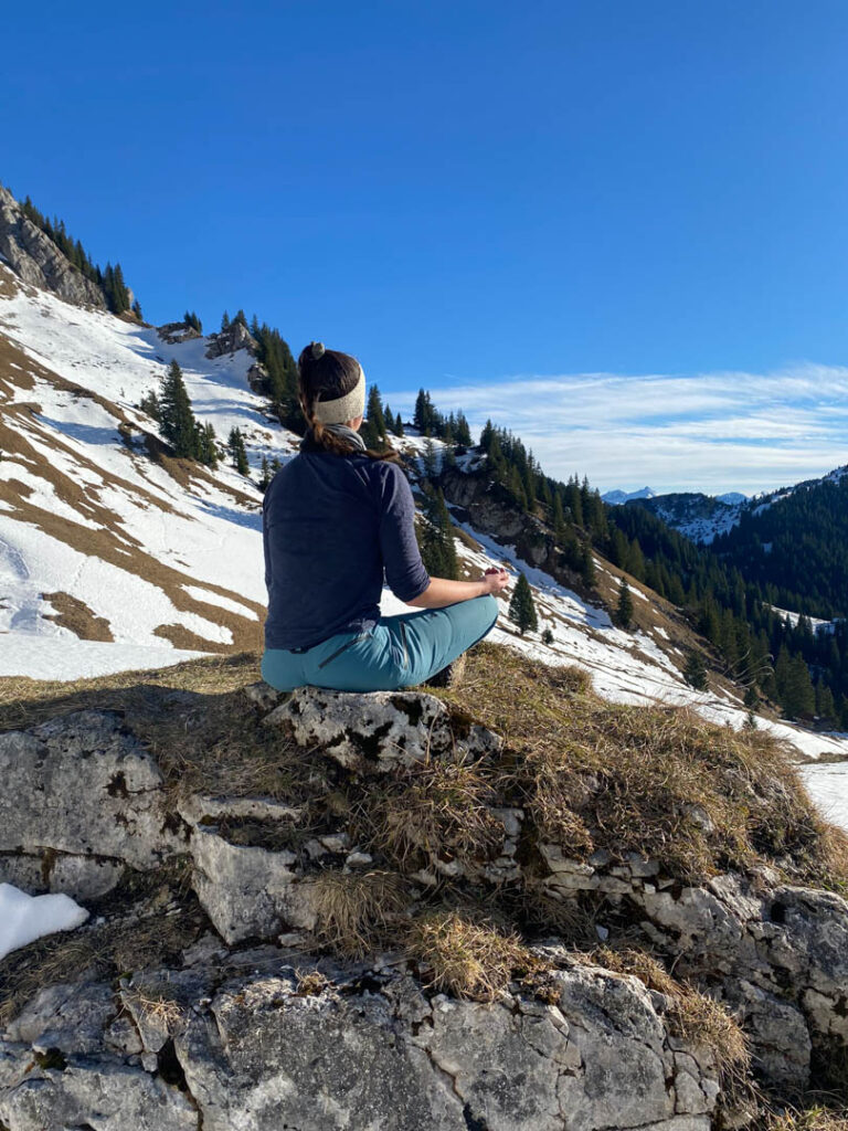 Yogalehrerin Katja Deniffel meditiert an ihrem Kraftort mitten in den Bergen.